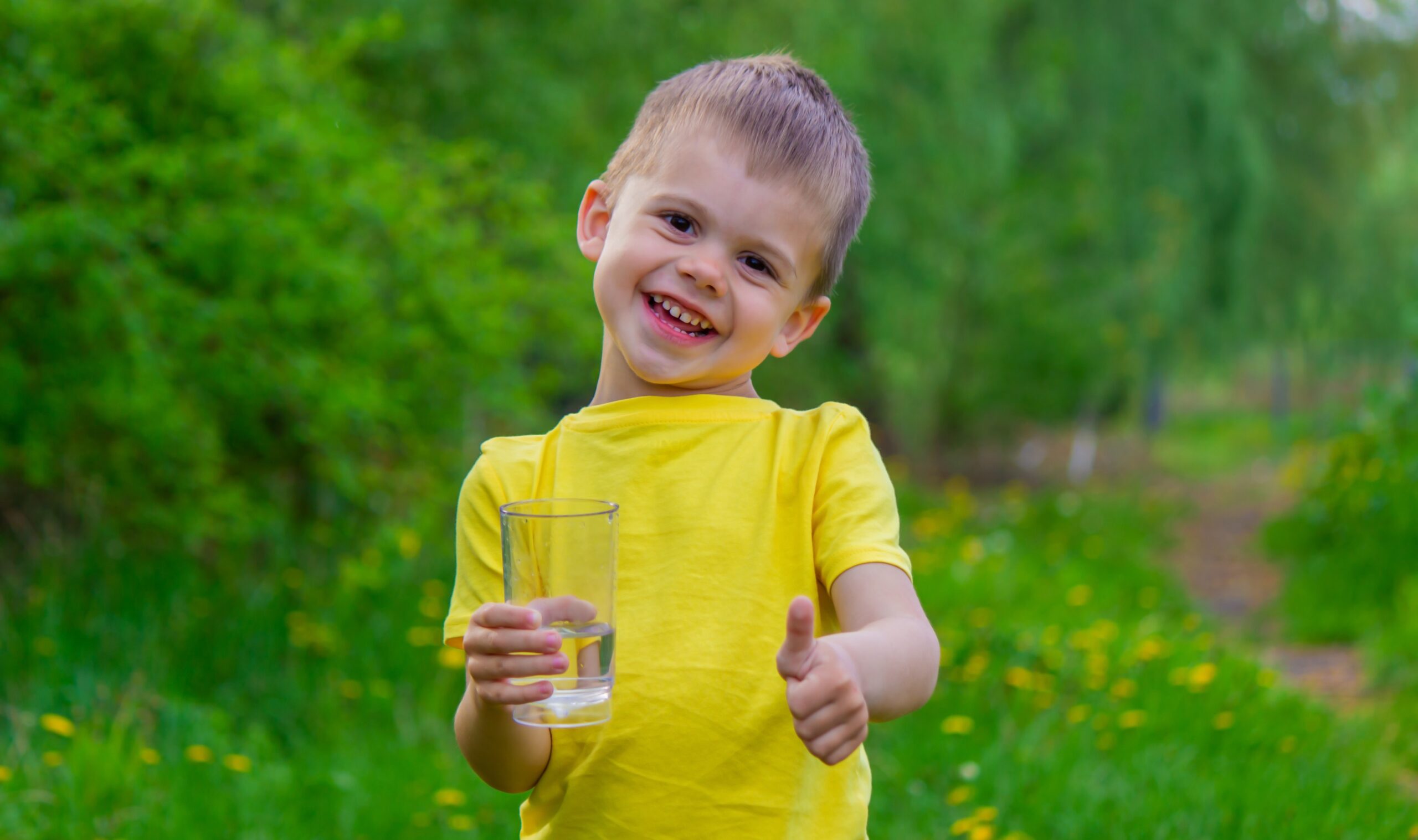 küçük çocuk parkta bir bardakla içme suyu. Seçici odak