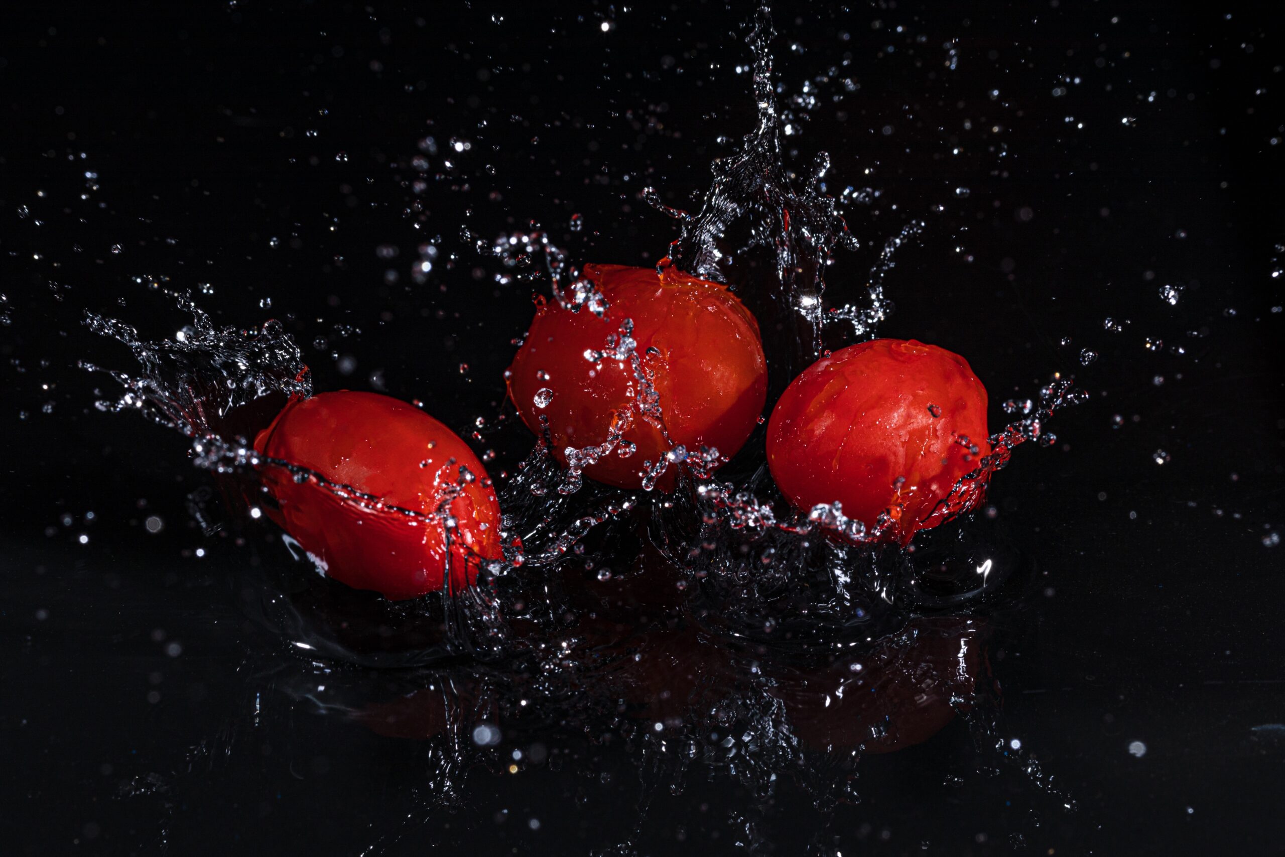suya düşen domates siyah arka plan su sıçraması