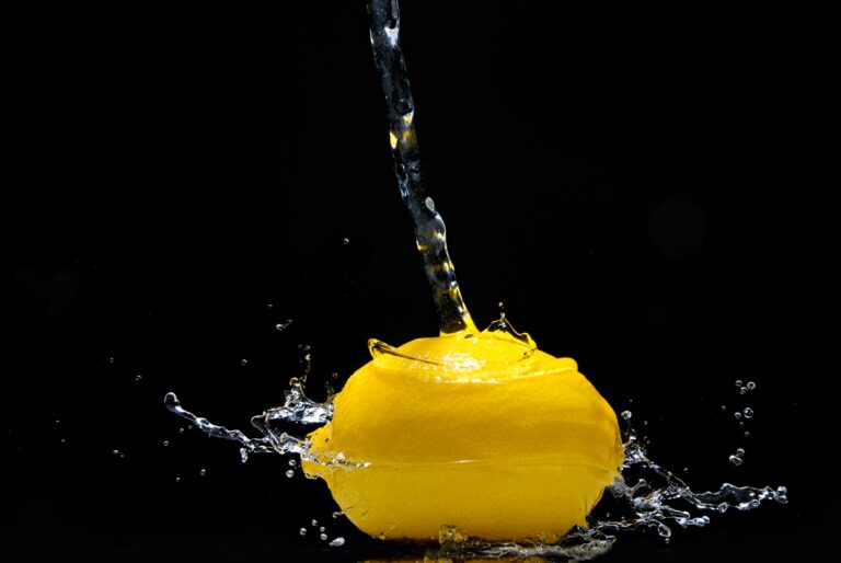 siyah arkaplanda bir adet limonun üzerine dökülen su görüntüsü su sıçratması